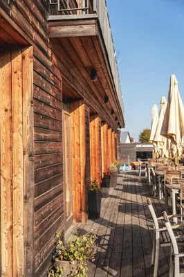 a wooden building with tables and chairs and umbrellas at Pension Jezerná in Zduchovice