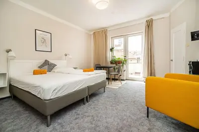 a bedroom with a bed and a yellow couch at Cosy studio with terrace by tram in Prague