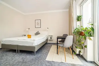 a bedroom with a bed and a table and a chair at Cosy studio with terrace by tram in Prague