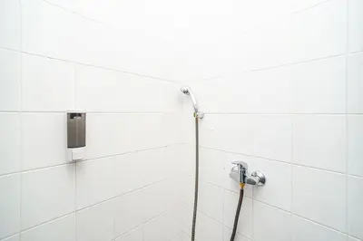 a shower with a hose attached to a wall at Cosy studio with terrace by tram in Prague