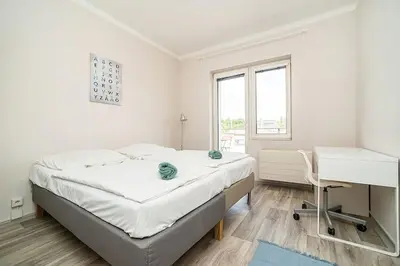 a white bedroom with a bed and a desk at 3 bedroom flat with amazing terrace in Prague