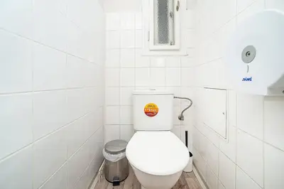 a bathroom with a white toilet with a sticker on it at 3 bedroom flat with amazing terrace in Prague