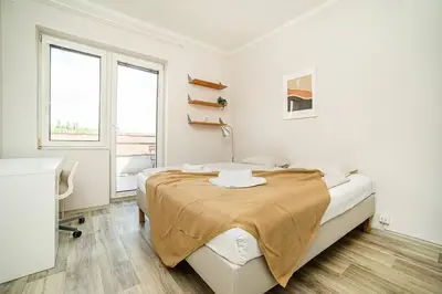 a white bedroom with a bed and a window at 3 bedroom flat with amazing terrace in Prague