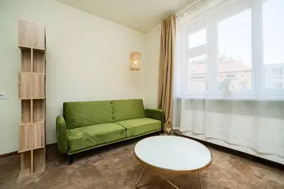 a living room with a green couch and a table at Apartment in Zizkov -504- in Prague