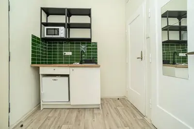 a kitchen with white cabinets and green tile at Apartment in Zizkov -504- in Prague