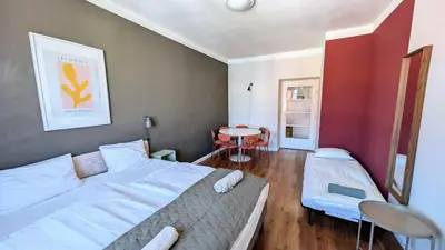 a bedroom with two beds and a table in it at Flat in Zizkov -502- in Prague