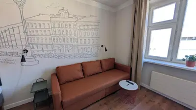 a couch in a room with a drawing on the wall at Flat in Zizkov -502- in Prague