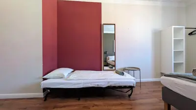 a bed in a room with a red wall at Flat in Zizkov -502- in Prague
