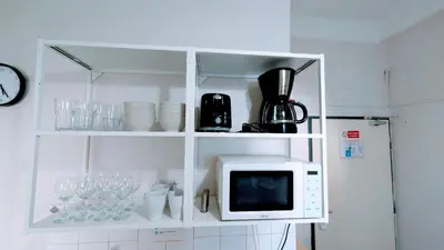 a white cabinet with a microwave and wine glasses at Flat in Prague -503- in Prague
