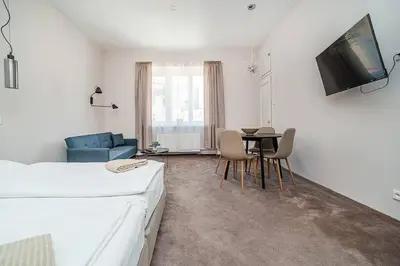a bedroom with a bed and a table with chairs at Modern studio with balcony + TV in Prague