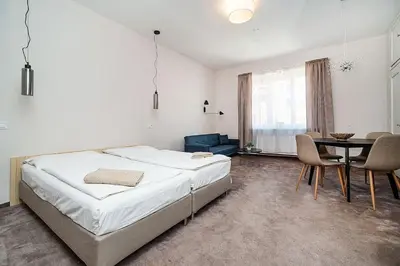a bedroom with a bed and a table and chairs at Modern studio with balcony + TV in Prague