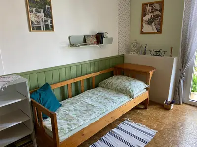 a small bed in a room with a shelf at Ubytování u babičky in Peruc