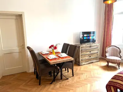 a living room with a dining room table and a television at Amazing Apartment Zborovska in Prague