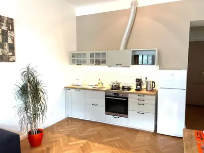 a kitchen with white cabinets and a counter top at Amazing Apartment Zborovska in Prague