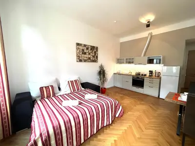 a small room with a bed and a kitchen at Amazing Apartment Zborovska in Prague