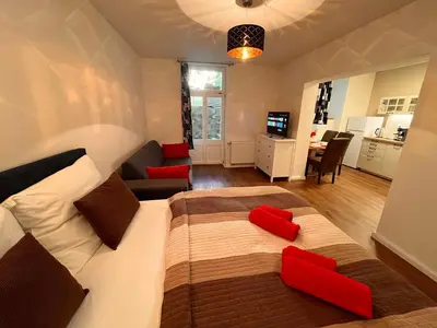 a bedroom with a large bed with red pillows at Amazing Apartment Zborovska in Prague