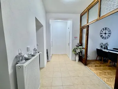 a hallway with a table and a clock on the wall at Apartmán Dlouhá 207 in Litoměřice