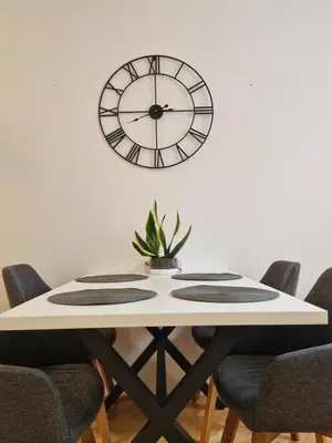 a table with chairs and a clock on the wall at Apartmán Dlouhá 207 in Litoměřice