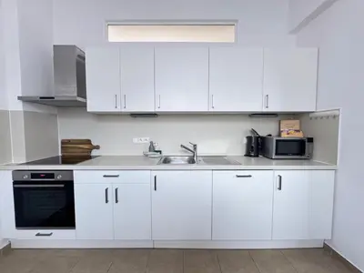 a white kitchen with a sink and a microwave at Apartmán Dlouhá 207 in Litoměřice