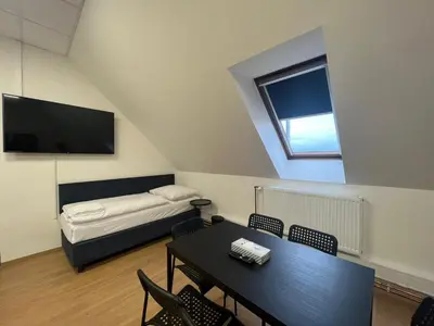 a room with a table and a bed and a tv at Powder Tower Suites in Prague