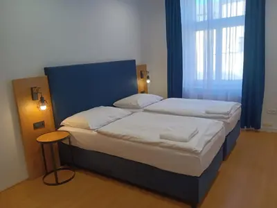 a bedroom with a large bed with a blue headboard at Powder Tower Suites in Prague