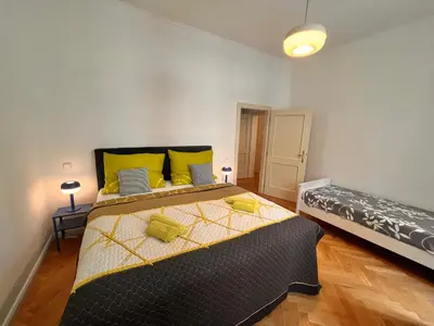 a bedroom with a large bed with yellow pillows at Cute Apartment Zborovska in Prague