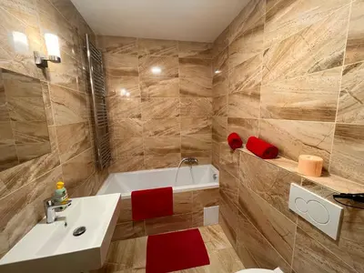 a bathroom with a white sink and a bath tub at Cute Apartment Zborovska in Prague