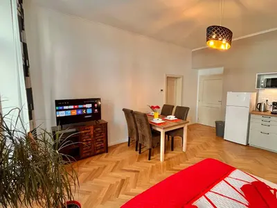a living room with a table and a television at Cute Apartment Zborovska in Prague