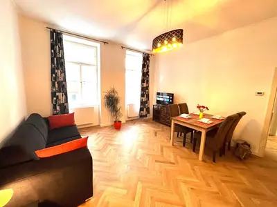a living room with a couch and a table at Cute Apartment Zborovska in Prague