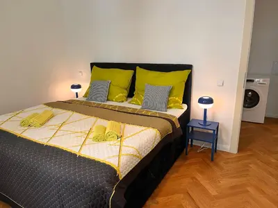 a bedroom with a large bed with yellow pillows at Cute Apartment Zborovska in Prague