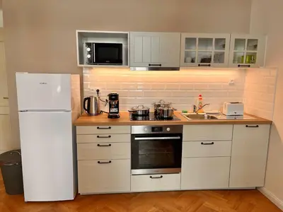 a kitchen with a white refrigerator and a sink at Cute Apartment Zborovska in Prague