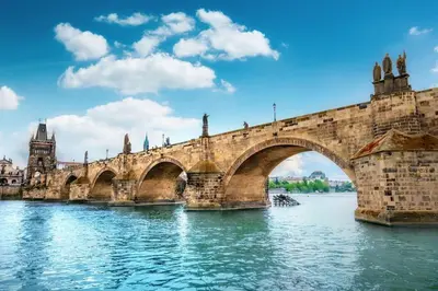 a stone bridge over a river in a city at Capitol deLuxe apartment in Prague