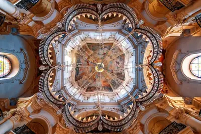 an ornate ceiling in a building with two windows at Capitol deLuxe apartment in Prague