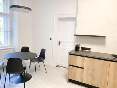 a kitchen with a table and some chairs and a table at Capitol deLuxe apartment in Prague