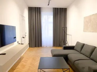 a living room with a couch and a tv at Capitol deLuxe apartment in Prague