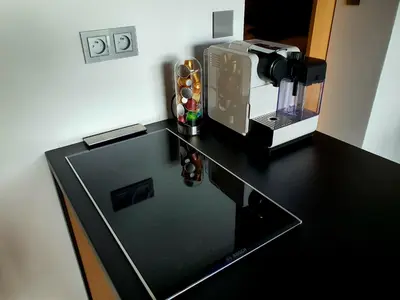 a black counter top with a coffee maker on it at Pláž Hrdlička in Buš