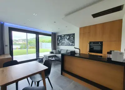 a kitchen and living room with a table and chairs at Pláž Hrdlička in Buš
