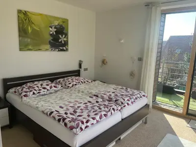 a bed in a bedroom with a large window at Apartmán s wellness službami in Čerčany
