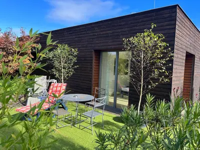 a garden with chairs and a table in front of a house at Apartmán s wellness službami in Čerčany
