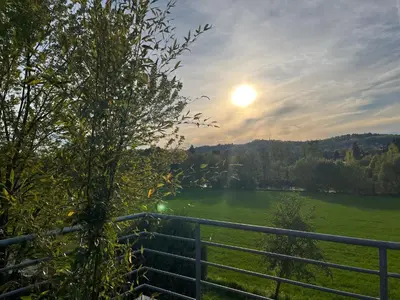 a fence and a field with the sun in the sky at Apartmán s wellness službami in Čerčany
