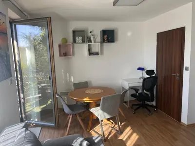 a living room with a table and a desk at Apartmán s wellness službami in Čerčany
