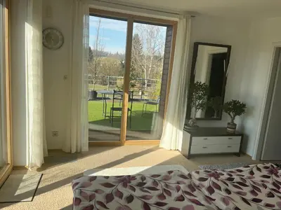 a bedroom with a bed and a sliding glass door at Apartmán s wellness službami in Čerčany