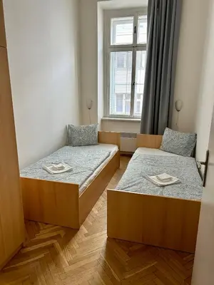 two beds in a room with a window at PARTY HOUSE PRAGUE - Apartments Ve Smečkách 18, CITY CENTER!! in Prague