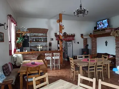 a living room with wooden tables and a fireplace at Hospůdka Na Trucovně in Sázava