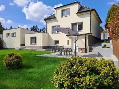 a house with a table and chairs in the yard at Apartmánový dům se zahradou v klidné části Prahy in Prague