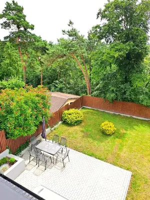 a patio with a table and chairs in a yard at Apartmánový dům se zahradou v klidné části Prahy in Prague