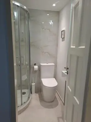 a bathroom with a toilet and a glass shower at Apartmánový dům se zahradou v klidné části Prahy in Prague