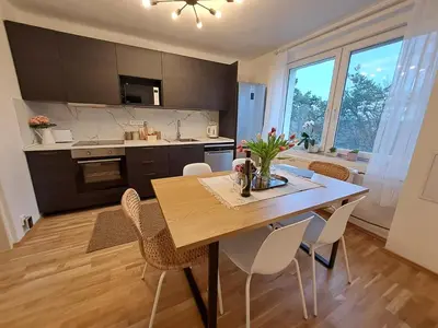 a kitchen with a table and chairs in a room at Apartmánový dům se zahradou v klidné části Prahy in Prague