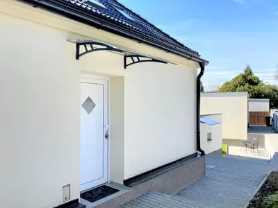 a door on the side of a white building at Apartmánový dům se zahradou v klidné části Prahy in Prague
