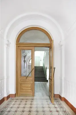 an archway leading into a hallway with a wooden door at Mama's apartment in Letna in Prague
